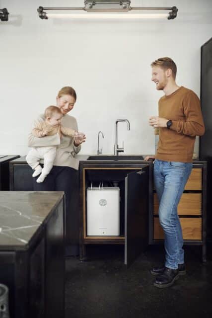 En ung familie drikker vand og har en vandrensningsmaskine installeret