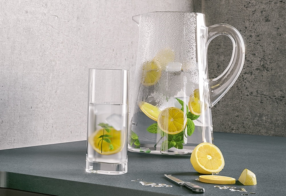 En kande og et glas med vand og citron
